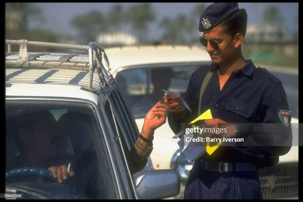 Gazan policeman checking car driver's pa