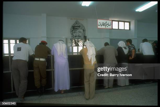 Palestinian passport applicants at counter in Arafat portraited Palestinian Natl. Authority Interior Ministry; Gaza City, Palestinian autonomous Gaza...