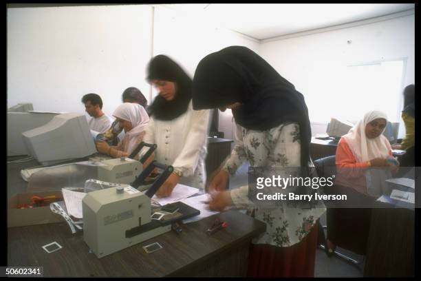 Women working in computer rm. At passport-issuing Palestinian Natl. Authority Interior Ministry; Gaza City, Palestinian autonomous Gaza Strip.