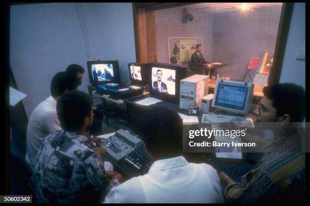 Staff screen-monitoring live studio broadcast fr. Adjacent control rm. At new Palestinian Broadcasting Corp; Gaza City, Palestinian autonomous Gaza...