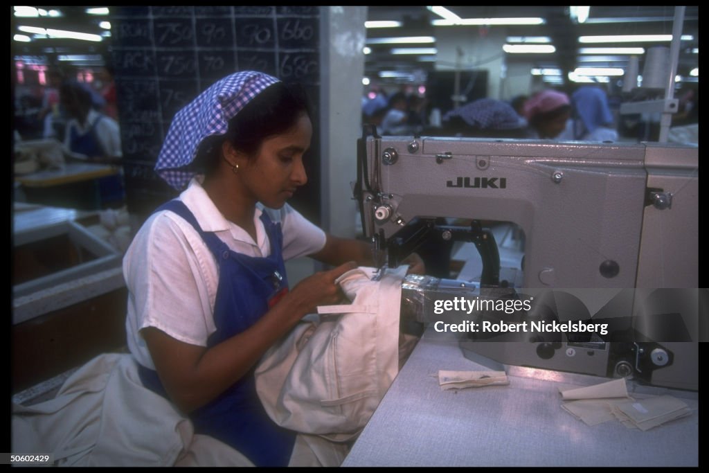 Women workers manning sewing machine at