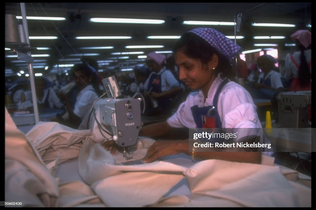 Women workers manning sewing machine at