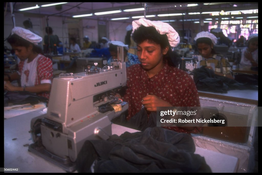 Women workers manning sewing machine at