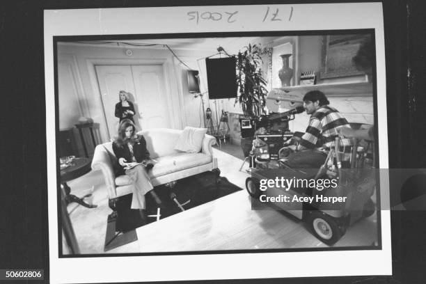 Comedian/actress Joan Rivers in bkgrd. While daughter Melissa sits on couch as crew member hones in w. Panavision movie camera fr. Motorized cart...