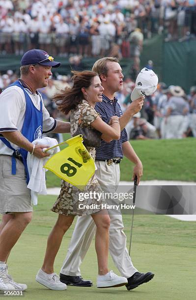 David Toms walks off the 18th green with his wife and caddie after winning the PGA Championship at the Atlanta Athletic Club in Duluth, Georgia....