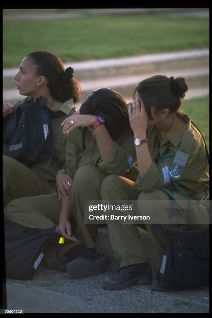 Trio of IDF girl soldiers, 2 covering faces in grief, during during ...