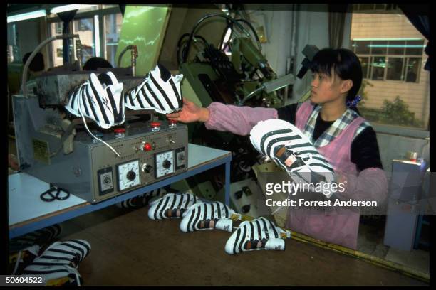 Woman worker on Reebok sneaker production line, shoes made under contract w. British co. At Kong Tai shoe mfg. Plant in special economic zone city...