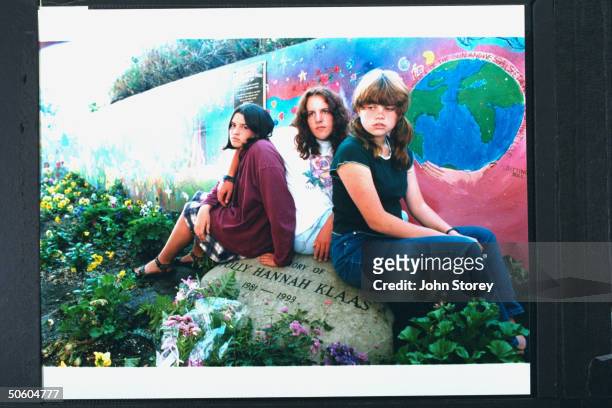Annette Schott , Gillian Pelham & Kate McLean, teen friends of kidnap-murder victim Polly Klaas sitting on a rock, emblazoned w. IN MEMORY OF POLLY...