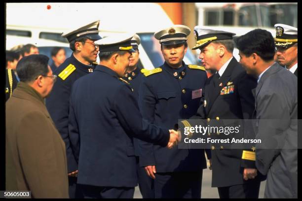 Rear Adm. Walter Doran & his Chinese counterpart Shao Dewan shaking hands in PLA dockside welcome to port call-paying USS Fort McHenry.