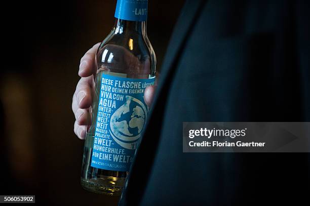 Man holds a bottle of Viva con Agua mineral water on January 21, 2016 in Berlin.