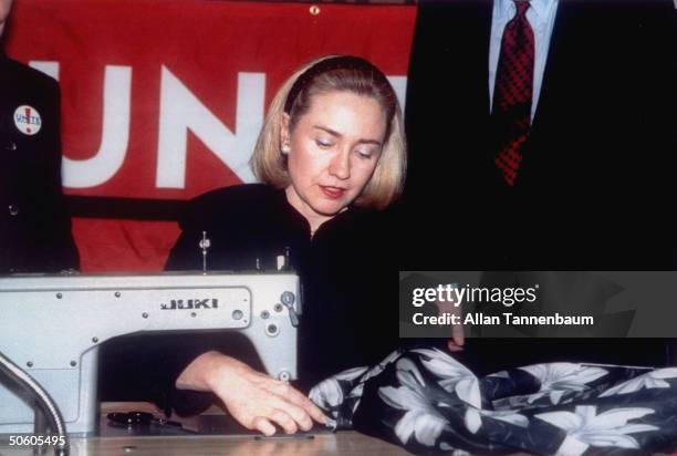 First Lady Hillary Rodham Clinton sewing a label into one of designer Nicole Miller's jackets to initiate the Union of Needletrades, Industrial and...