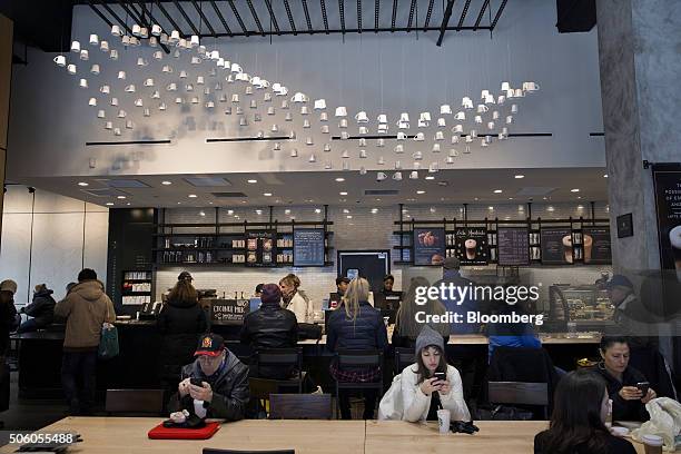 Customers sit inside a Starbucks Corp. Coffee shop in New York, U.S., on Monday, Jan. 18, 2016. Starbucks Corp. Is scheduled to release its...