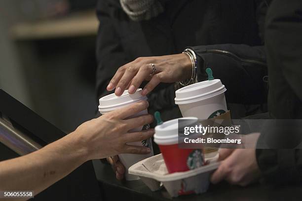 Barista hands a customer a drink inside a Starbucks Corp. Coffee shop in New York, U.S., on Monday, Jan. 18, 2016. Starbucks Corp. Is scheduled to...