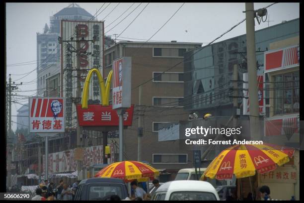 McDonalds & Kentucky Fried Chicken signs advertising outlets of US-based fast food chains, mark of growing Amer. Influence on Chinese culture.