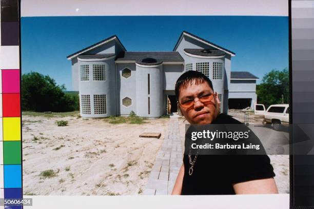 Abraham A.B. Quintanilla III, bro. Of slain tejano singer Selena, posing outside ultra modern house.
