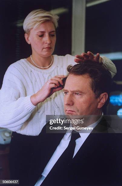 Makeup artist preparing Liberal Dem. Party ultrationalist ldr. Vladimir Zhirinovsky for TV campaign speech in his bid for seat in Duma in...