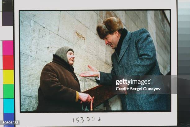 Duma cand. Ultranationalist Liberal Dem. Party ldr. Vladimir Zhirinovsky talking to old babushka, campaigning on streets for upcoming parliamentary...