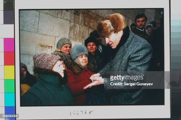 Duma cand. Ultranationalist Liberal Dem. Party ldr. Vladimir Zhirinovsky talking to woman in crowd gathered to hear him speak, street campaigning for...