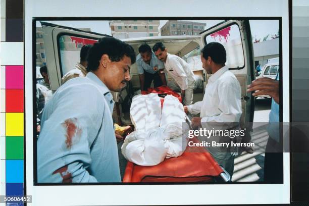 Ambulance team loading hospital-bound victim of attack on Greek tourists outside their hotel by gunmen, fundamentalist Islamic Group claiming...