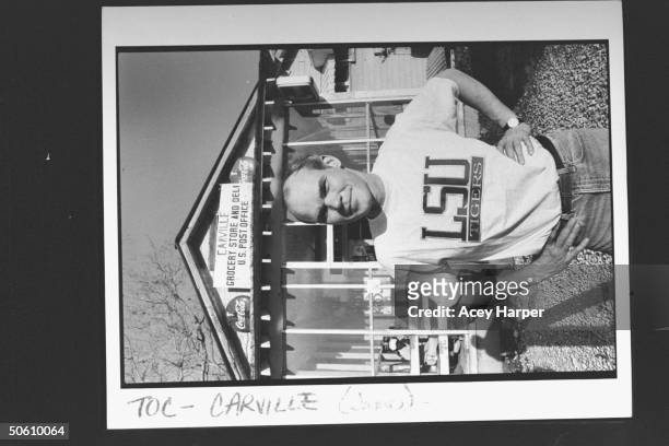 James Carville, pol. Consultant for Dem. Pres. Cand. Bill Clinton, posing in LSU Tigers t-shirt as he stands in front of Carville Post Office &...