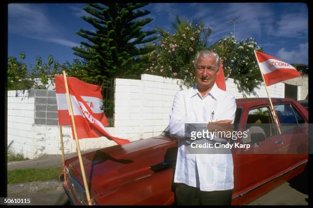 Amb. John Ferth standing by car w. Red flags, during elections that had intl. Observers.