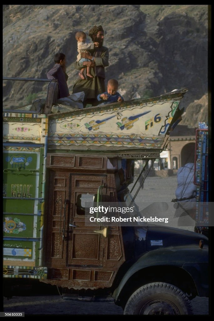 Festive truck-traveling Afghan refugees