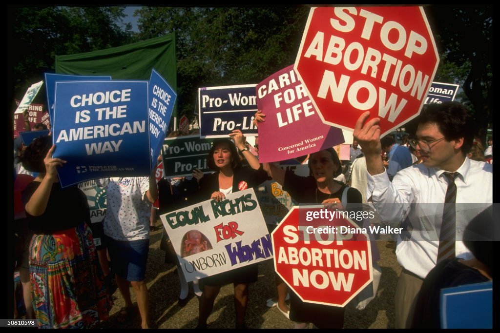 Sign-carrying pro-choice & pro-life advo