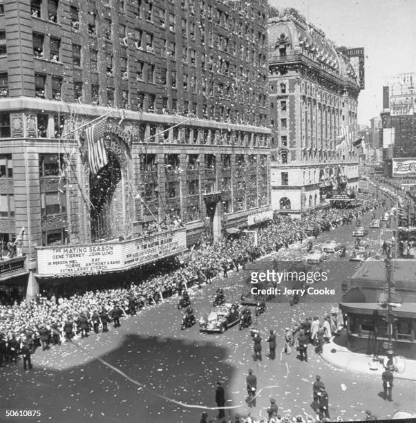 Gen. Douglas MacArthur's motorcade making its way through Times square under torrent of ticker tape during welcome home parade in his honor; Astor...