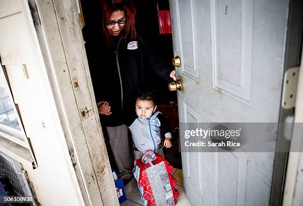 Sandra Mendez and her son Alonzo Cabrera receive water from Red Cross volunteers at their home January 21, 2016 in Flint, Michigan. Mendez said she...