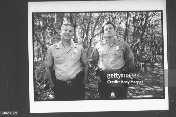 Uniformed Metro-Dade detectives Mike Kellar & J.J. Crocker posing outside; they are sure that super thief Jack MacLean is the Gentle Rapist because...