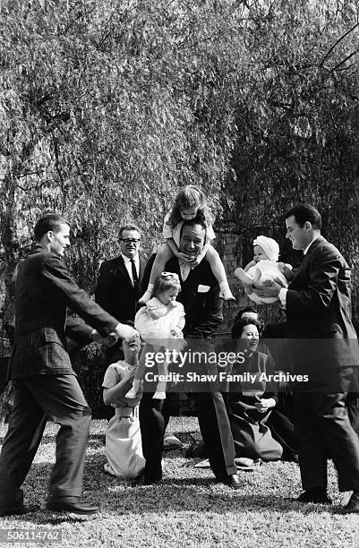 John Wayne at home with his children and grandchildren in 1960 in Encino, California.