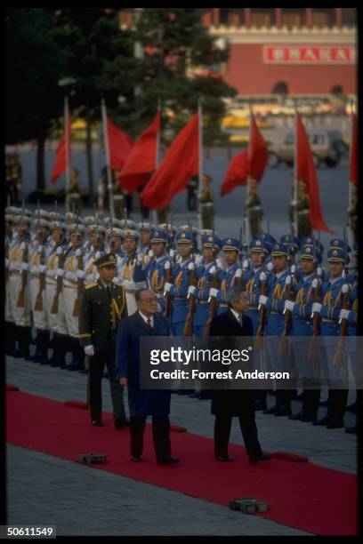 Pres. Yang Shangkun hosting Japanese Emperor Akihito , treading red carpet, reviewing troops.