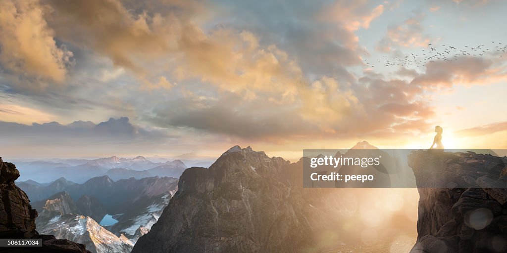 Spiritual Seeker Meditating High On Mountain Top At Sunset