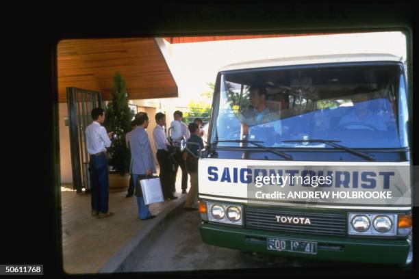 Sightseers boarding Saigon Tourist Toyota bus .