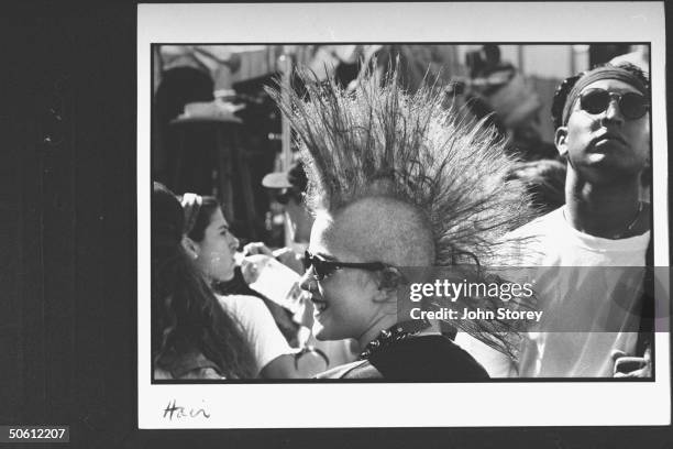 Female concertgoer w. Spiked mohawk haircut, sporting nose ring & sunglasses, in crowd at the Lollapalooza '92 traveling rock fest cum carnival.