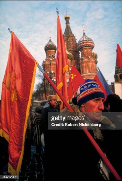 Adidas ski cap-clad, red flag- carrying man standing out amid pro-Communist, nationalist, far-right forces protesting at Kremlin as Congress convenes.