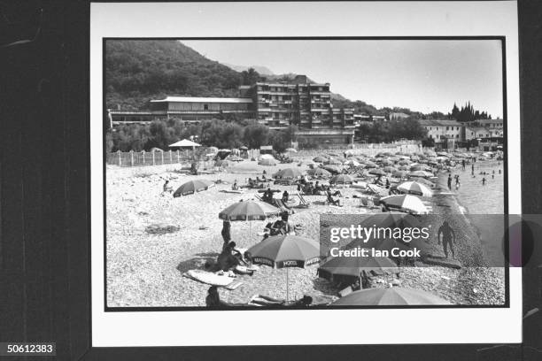 Overall view of umbrella-lined shoreline w. Sunbathing vacationers on beach in front of the sprawling Hotel Maestral where upcoming chess match...