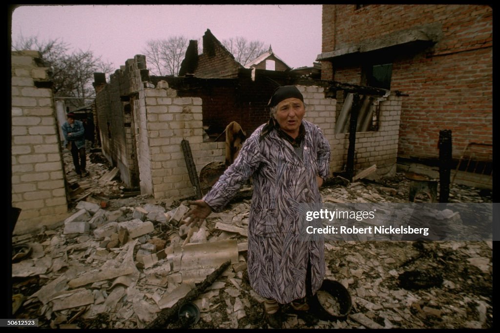 Old Ingush woman in ruins of her home de
