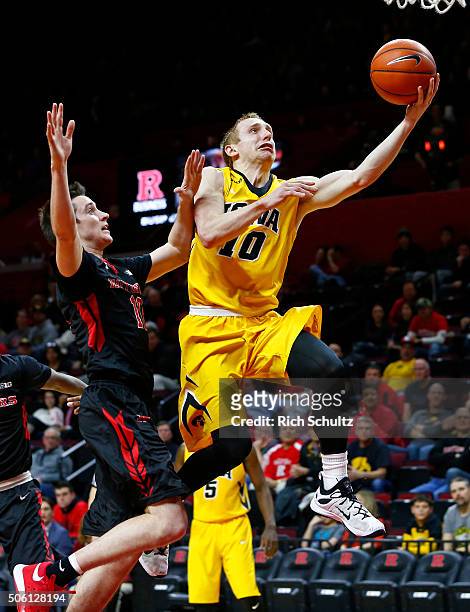 Mike Gesell of the Iowa Hawkeyes attempts a layup as Justin Goode of the Rutgers Scarlet Knights defends during the first half of a college...