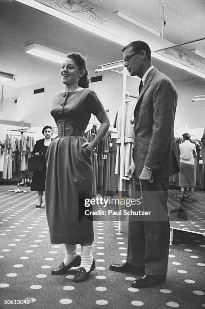 Designer Ole Borden watching as teenager tries on dress w. New longer length skirt, inspired by designer Christian Dior, at Bloomingdale's.