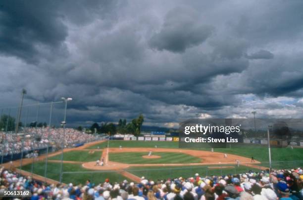 Dark storm clouds looming over Hohokam Stadium during Chicago Cubs vs. San Francisco Giants spring training baseball game.;1993