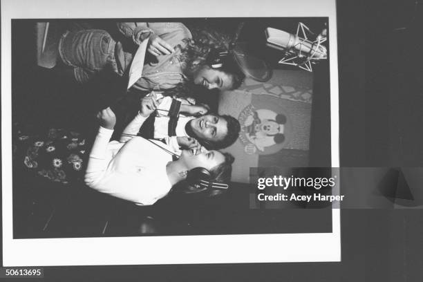 Mouseketeers Keri Russell, Ricky Luna & Mylin Brooks wearing headphones & singing into mike in recording studio at the Mickey Mouse Club set at...