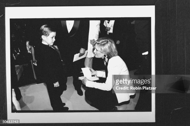 Journalist Diane Sawyer giving autograph to 6-yr-old Jesse Sepulveda who found a heart donor after appearing on the Donahue show; they are attending...