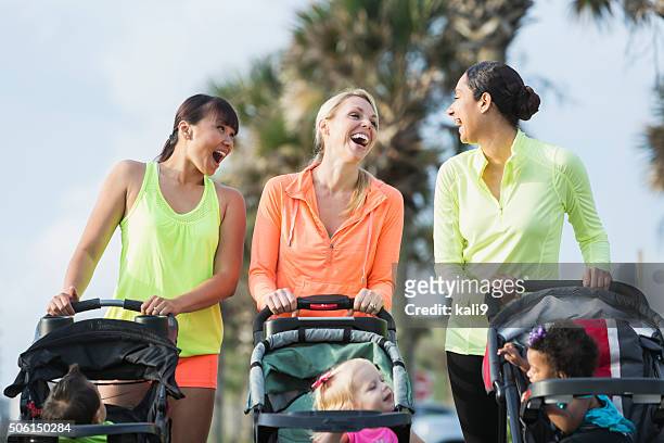 multi-racial mothers with babies in jogging strollers - baby pram in the park stock pictures, royalty-free photos & images
