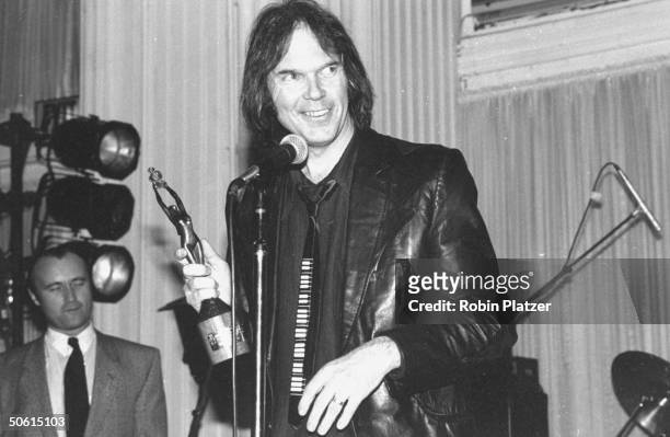 Neil Young holding Silver Clef award presented to him by Nordoff-Robbins Music Therapy foundation which held auction & awards ceremony.
