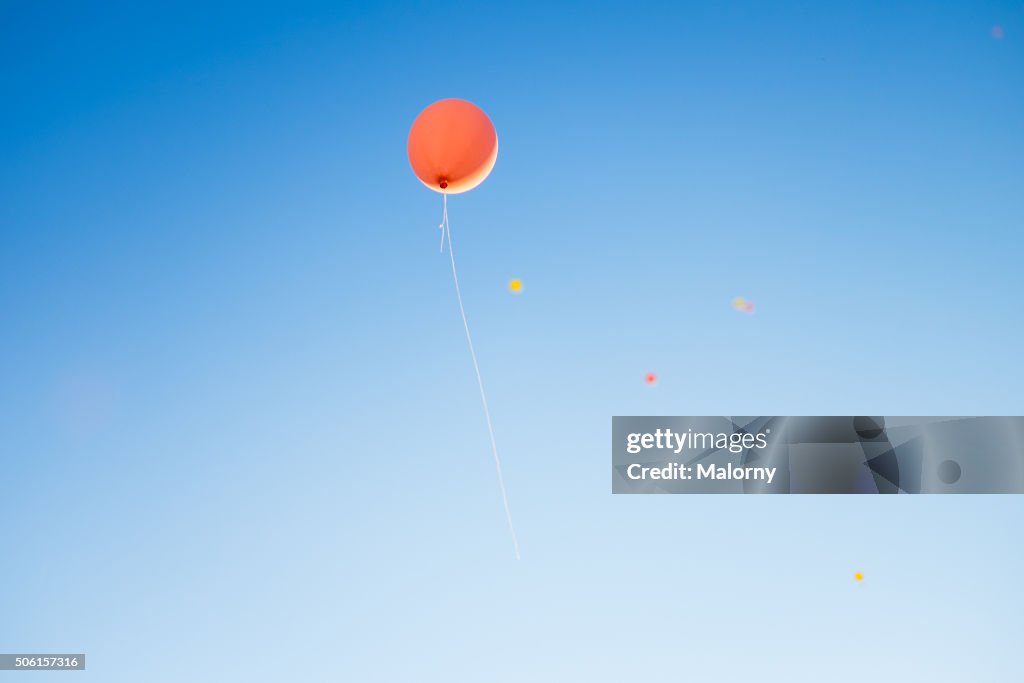 Low angle view of helium balloons with messages in mid-air against sky. Wedding.