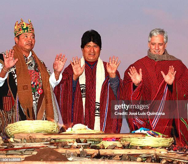 President of Bolivia , Vicepresident Alvaro Garcia and an aymara priest raise their hands to receive the sunlight of the dawn during the celebration...