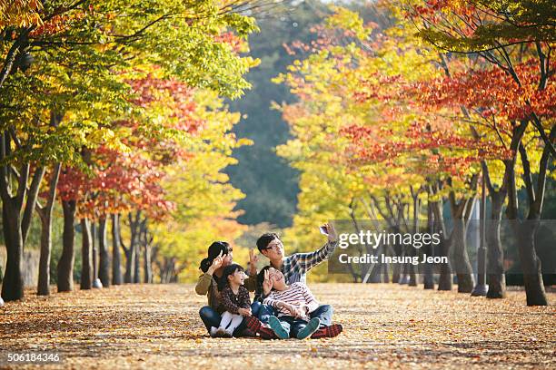 family playing in autumn park - ulsan stockfoto's en -beelden