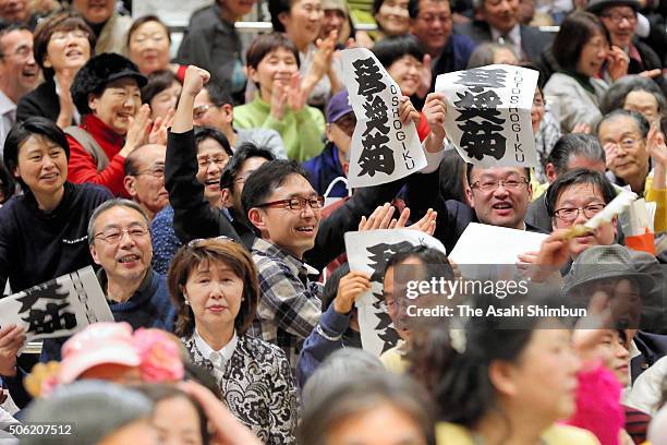 Supporters of Ozeki Kotoshogiku celebrate his win over Mongolian yokozuna Harumafuji during day twelve of the Grand Sumo New Year Tournament at...