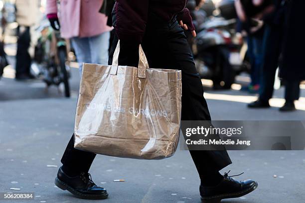 Showgoer carries a Comme des Garcons shopping bag on January 21, 2016 in Paris, France.